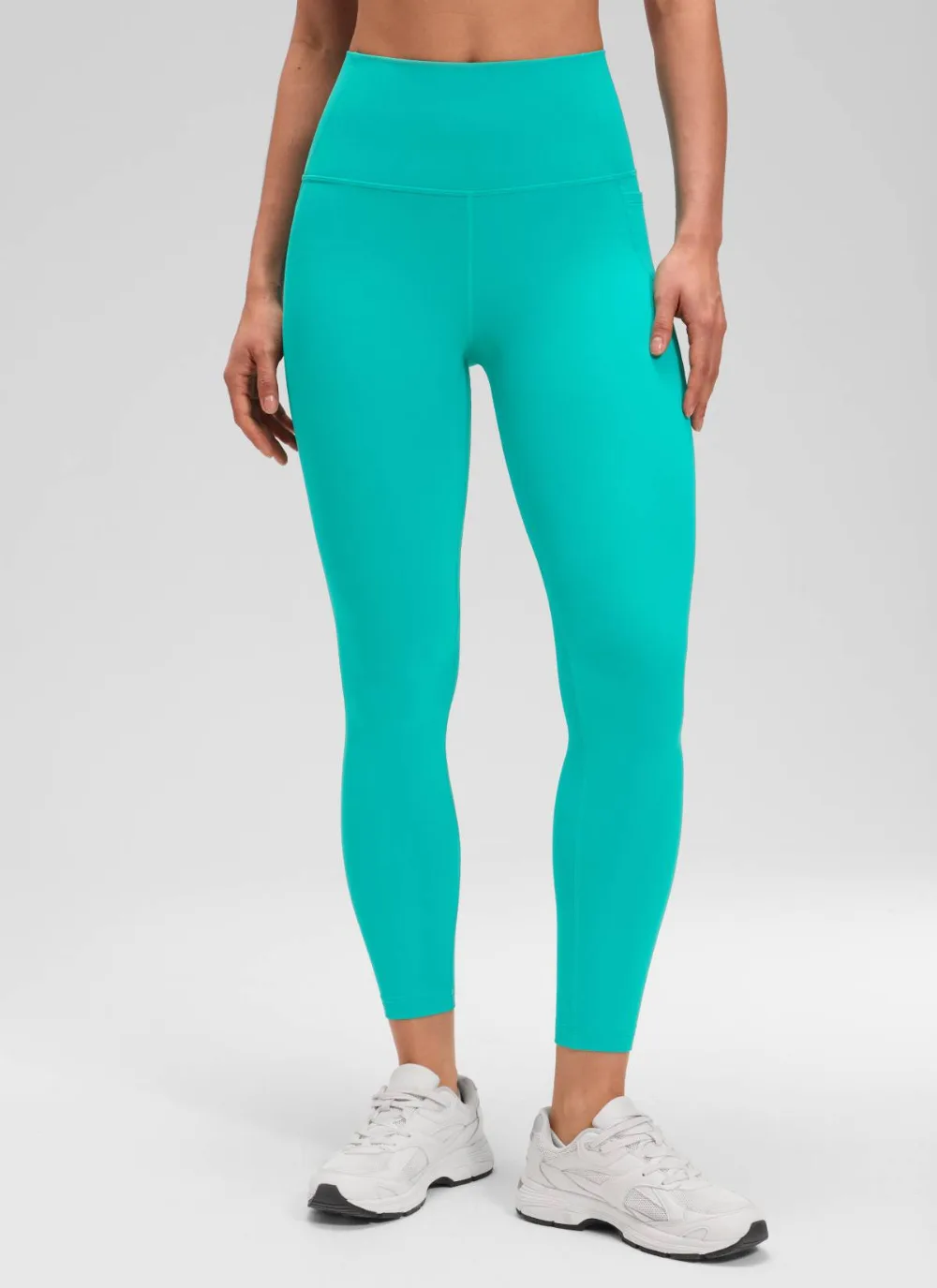 Turquoise Butterluxe legging with a wide high waistband, shown front on from waist to ankle with white chunky sneakers
