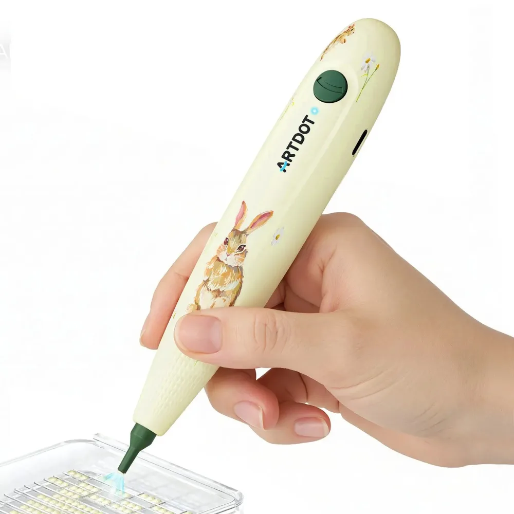 Hand holding a cream coloured electric pen decorated with a rabbit illustration, lifting drills from a tray with its green tip