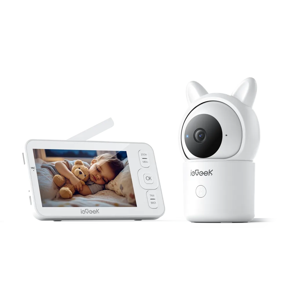 Handheld monitor screen showing a sleeping baby with a teddy bear, beside a white pan and tilt camera with ear shaped tabs