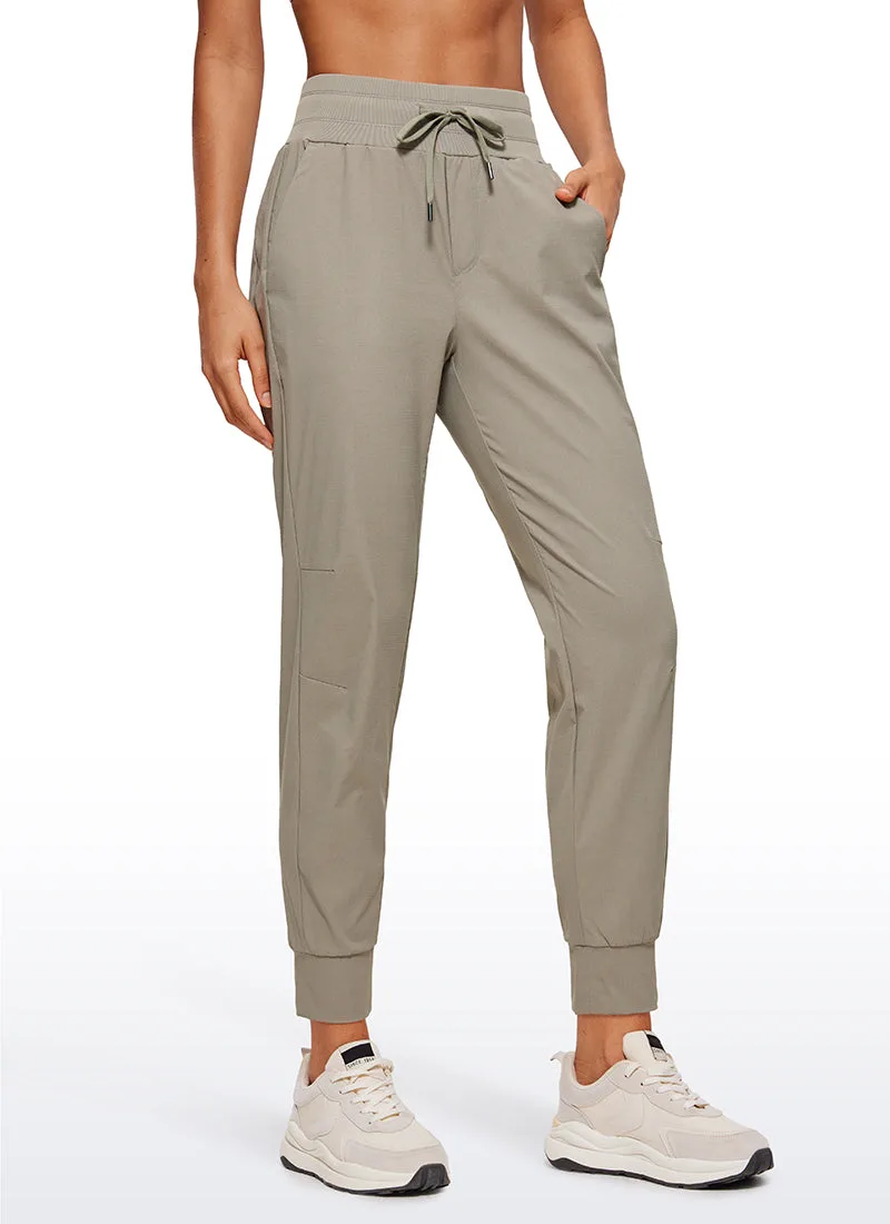 Khaki ripstop jogger with a drawstring waist and elastic ankle cuffs, both hands resting in the side pockets