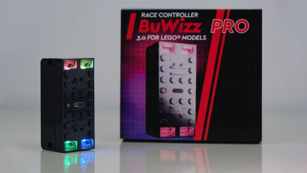 Best Bluetooth Battery Hubs for LEGO Technic: Power Functions and Powered Up Upgrades 1 The BuWizz 3.0 Pro, a black LEGO compatible brick with four small RGB LEDs lit in red, green and blue and a USB-C port on its face, standing next to its retail box printed Race Controller BuWizz Pro 3.0 for LEGO models