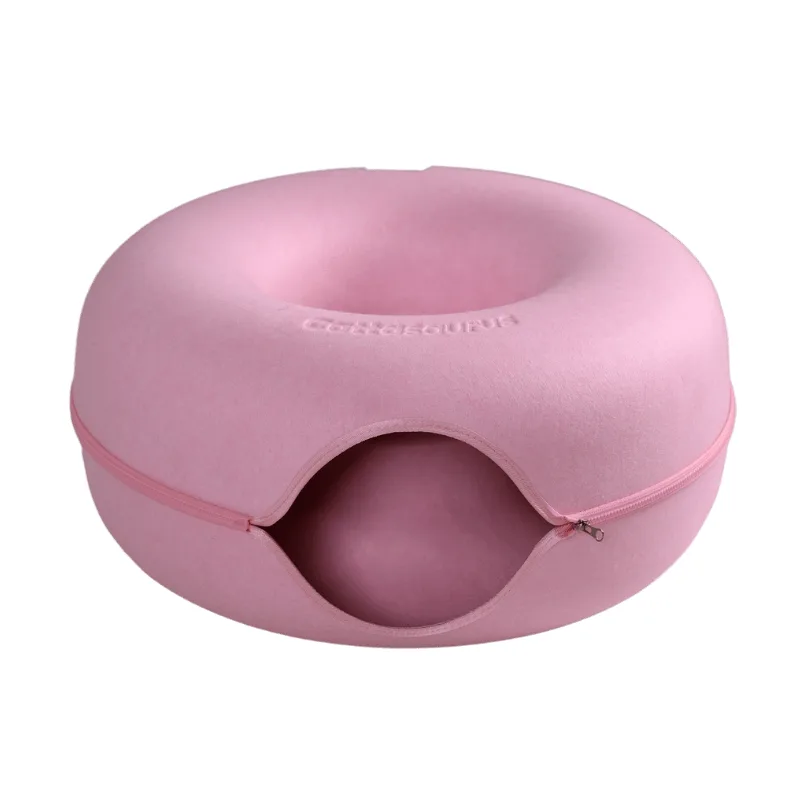 The same donut shaped felt cat cave in soft pink, with a matching pink zip around the circumference and the brand name embossed on top