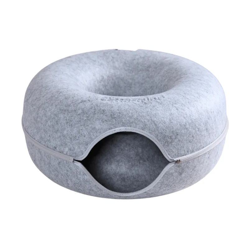 A plain grey felt donut shaped cat cave with a round tunnel entrance and a zip around the middle, the Cattasaurus name embossed on the top surface