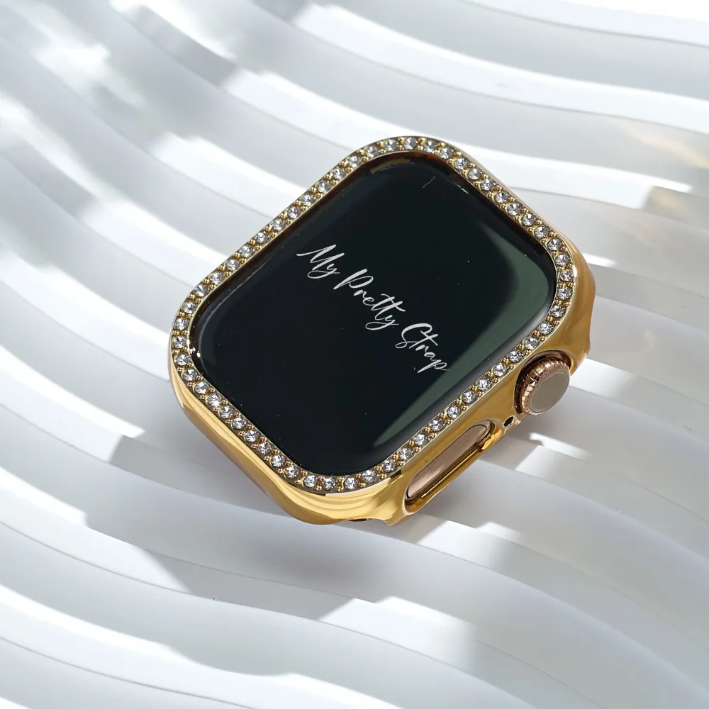 Best Apple Watch Bands That Look Like Jewelry 7 A gold Apple Watch bezel cover set with a single row of clear crystals, shown on its own against a white ribbed surface