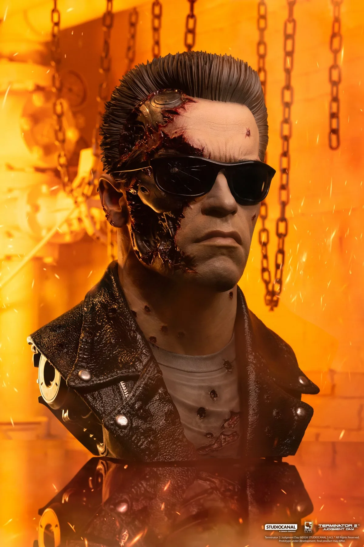 The battle damaged T-800 art mask, half the face torn away to expose a gold endoskeleton, wearing cracked sunglasses and a bullet-riddled leather jacket, lit orange